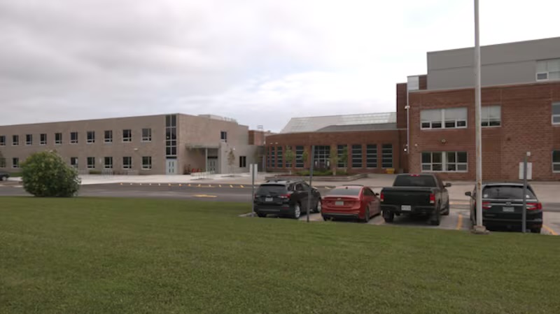 Nantyr Shores Secondary School — long two-storey brick and concrete school building seen across the parking area